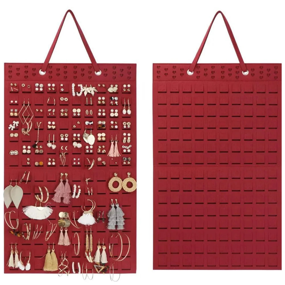 A red felt earring organizer display with hanging loops and numerous small earrings.