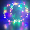 A glowing flower wreath headband with ten LEDs illuminates a dark background.