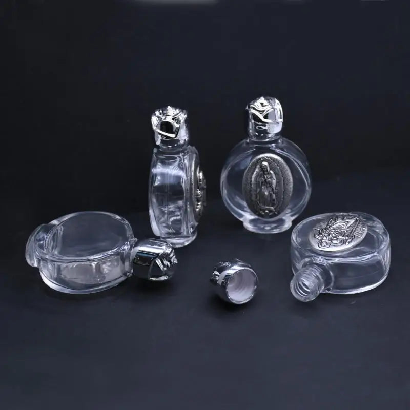 Clear glass bottle with a figurine and twist cap resting on a dark surface.