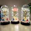 Tres cloches de vidrio exhiben árboles en miniatura con luces brillantes y ositos de peluche.