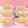 A display of yellow popcorn in pink and blue boxes for a gender reveal party.