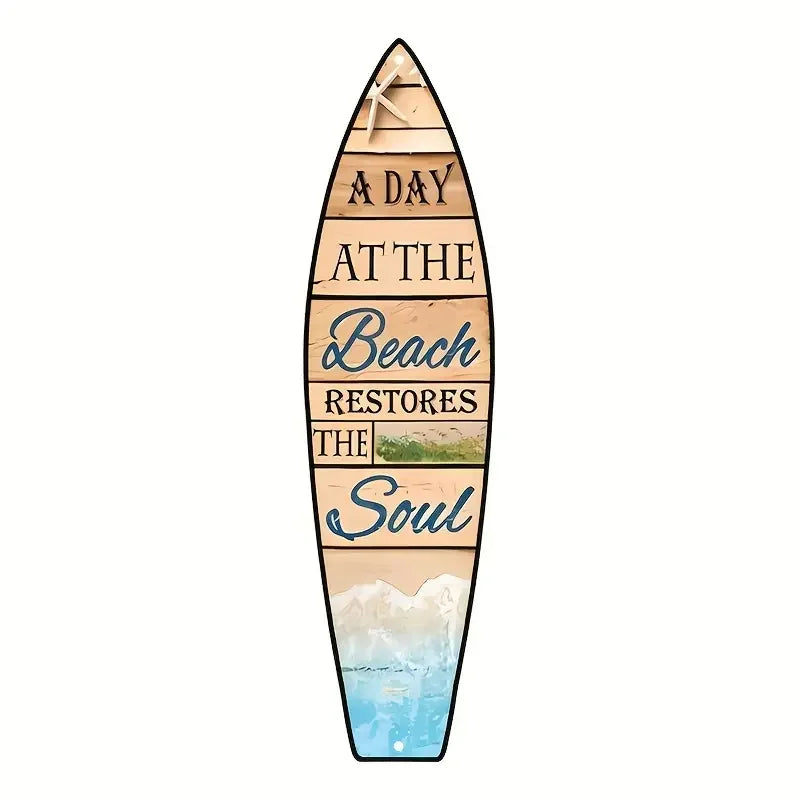 A wooden surfboard sign with text that reads A DAY AT THE BEACH RESTORES THE SOUL