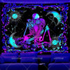 A vibrant purple and blue tapestry featuring a skeletal figure surrounded by glowing lotus flowers and celestial elements.