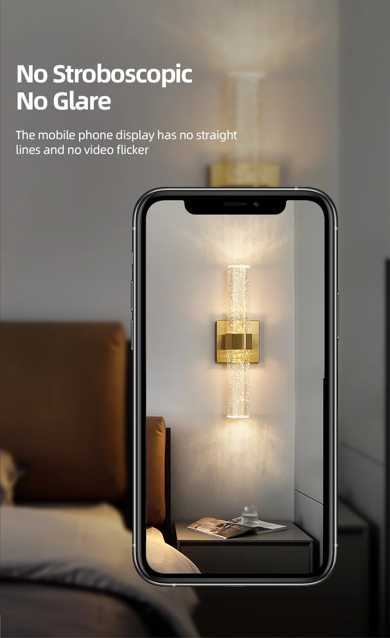 A mobile phone display showing a bright, vertical crystal LED light fixture illuminating a dark surface.