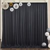 Black pleated backdrop curtains decorated with circular gold and white floral accents