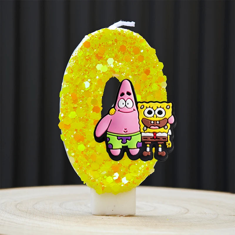 A yellow sponge cake candle shaped like the number 0, decorated with characters from SpongeBob SquarePants.