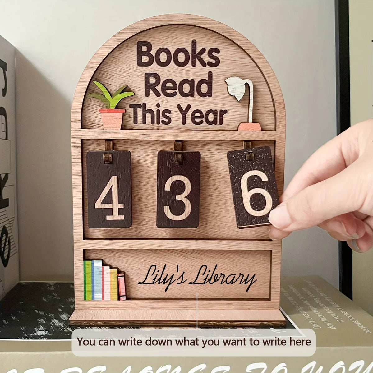 Affichage de suivi de livres en bois montrant les chiffres 4, 3 et 6 avec une plante et le texte Lily's Library.