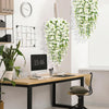Artificial morning glory hanging flowers in a white cascading arrangement on a wall.