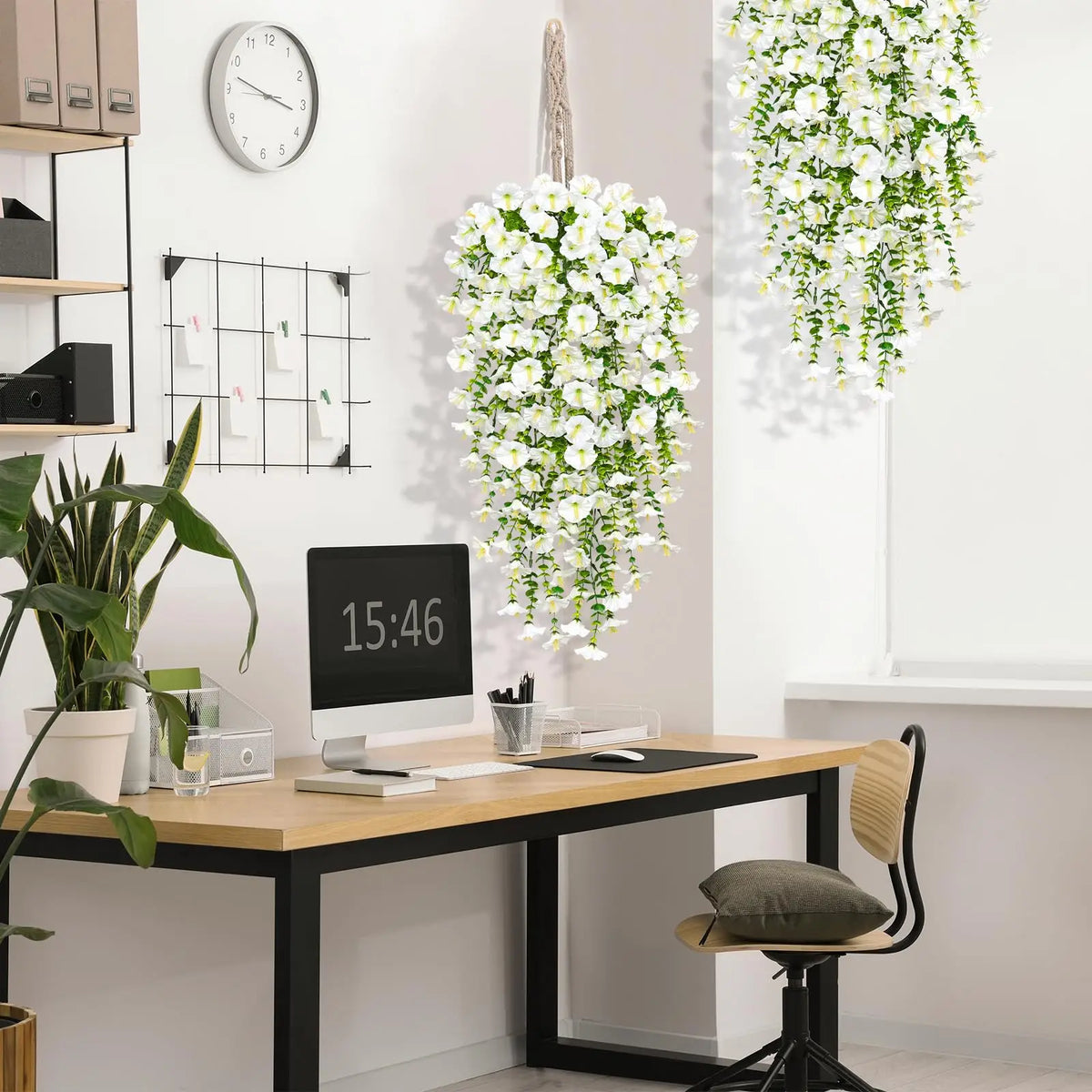 Artificial morning glory hanging flowers in a white cascading arrangement on a wall.