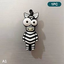 A black and white striped cartoon animal magnet shaped like a cow's face.