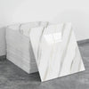 A stack of white marble tile stickers displayed on a gray surface.