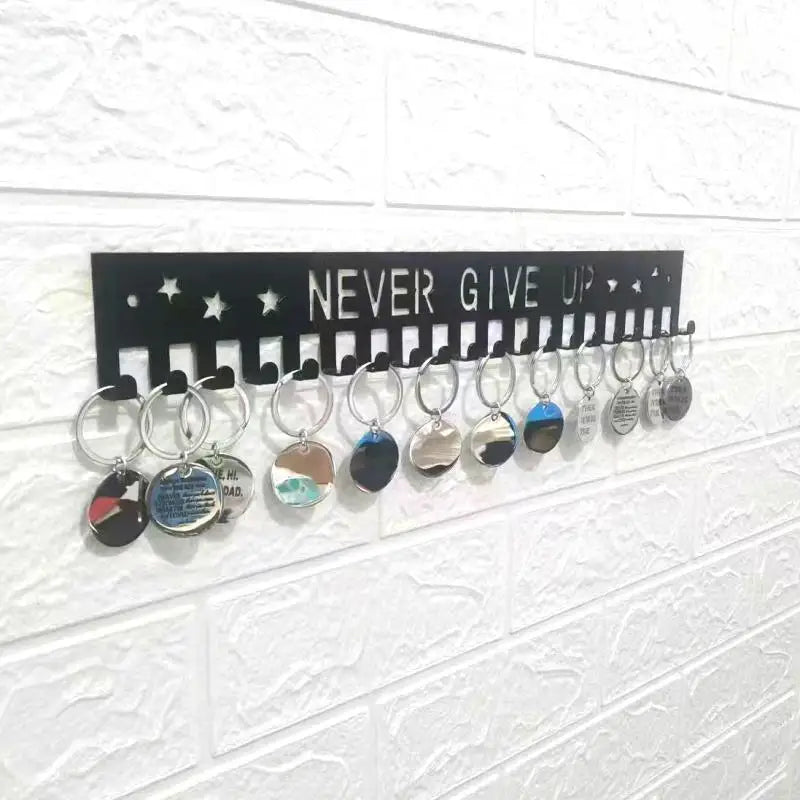 A black wall display rack featuring multiple silver and colored metal medals hanging on pegs.