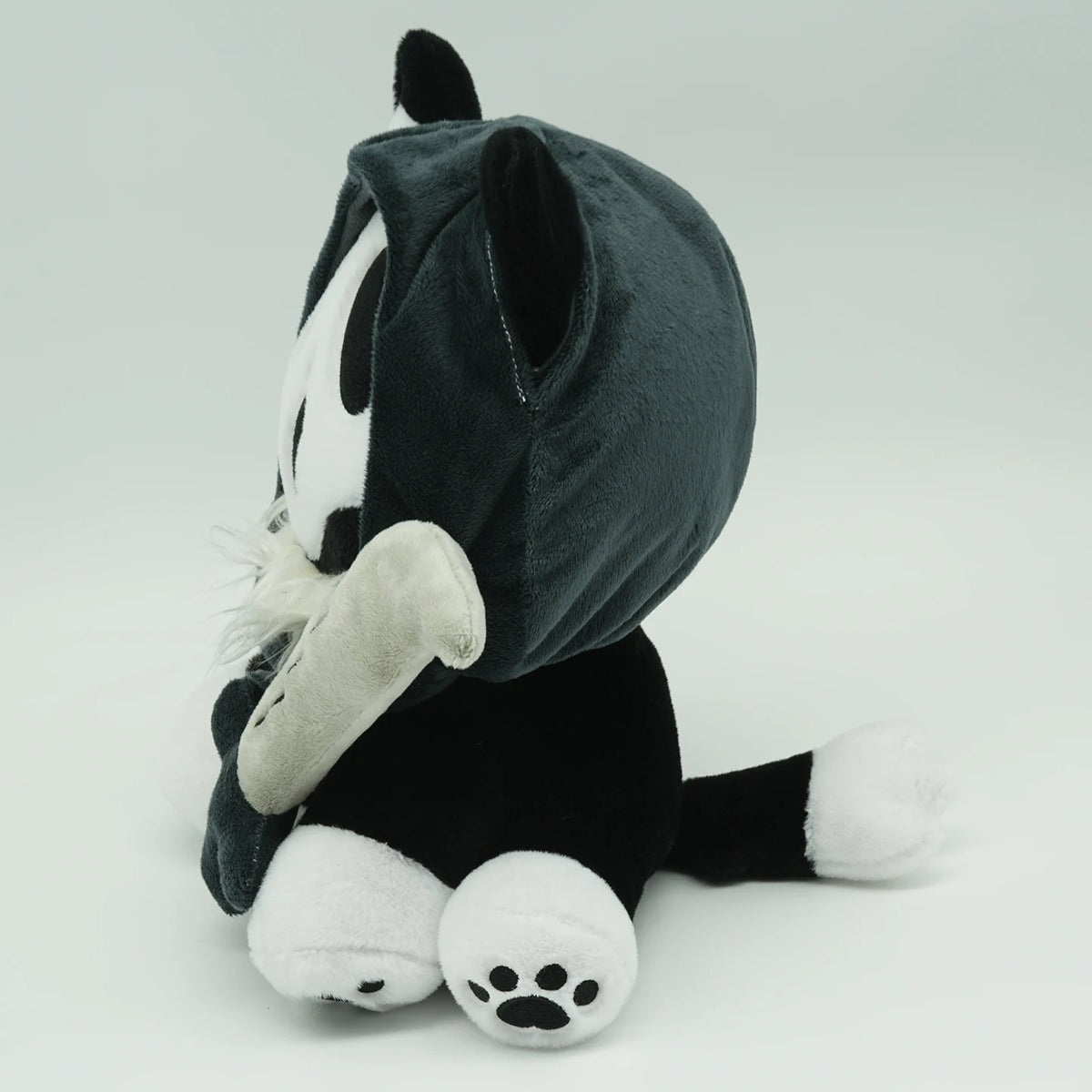 A black and white ghost cat plush toy with floppy ears and white paws.