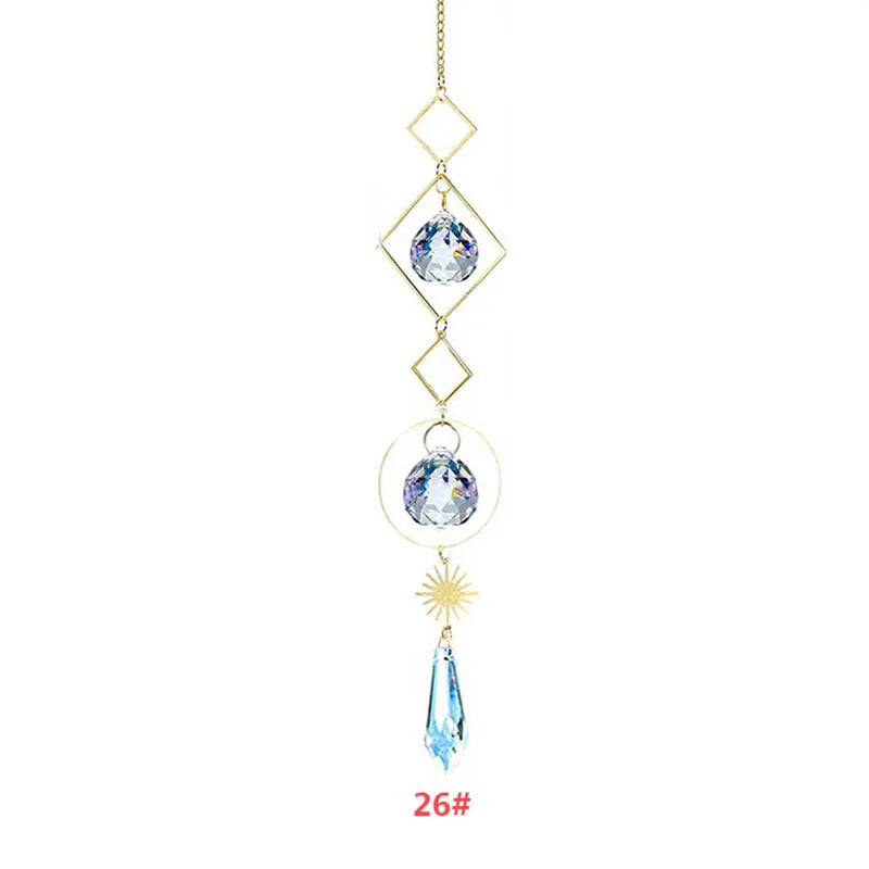 Décoration suspendue dorée délicate avec un pendentif en cristal clair et un charm de cristal goutte bleue.