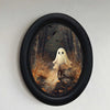 Oval wall art featuring a ghost riding a bicycle in a dark forest scene framed in black