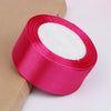 Roll of bright pink satin ribbon with a white center for crafts and gift wrapping