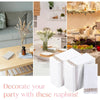 A set of white paper dinner napkins with rose gold trim displayed next to floral arrangements and tableware.