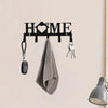 A black wall key holder with a heart design features hooks for hanging keys and a folded gray towel.