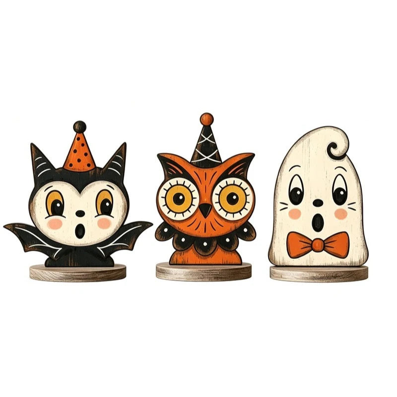 A set of three wooden block Halloween decor figures: a black cat-like owl, an orange owl, and a white owl.