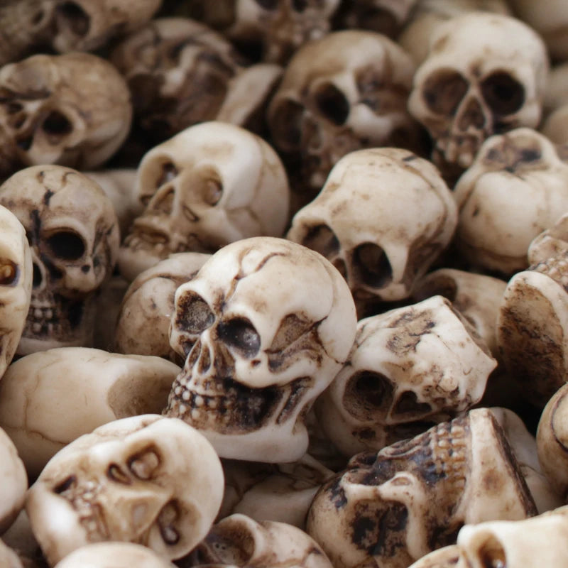 A close-up view of a pile of 20 realistic resin mini skulls used for garden decor.