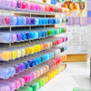 A display of numerous acrylic paint markers in various colors arranged on tiered shelves for DIY crafts.