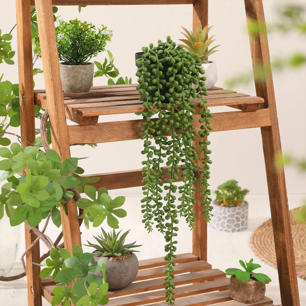Hanging artificial plant wall decor featuring lush green foliage displayed on a wooden stand.