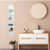 A modern white 5-tier vertical wall shelf mounted on a beige wall, featuring storage for plants and decorative items.