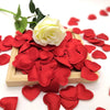 A pile of red fabric heart petals is displayed in a wooden tray on a white background.