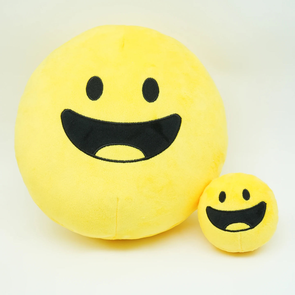 A bright yellow, smiling plush doll resembling a happy face.