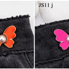 Two images showing pearl butterfly waist tightener buttons in orange and pink on black denim fabric.