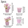 Three small pink faux bonsai plants in rectangular pots with varying heights and sizes.