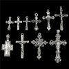 A collection of antique silver cross charms and pendants for jewelry making displayed against a black background.