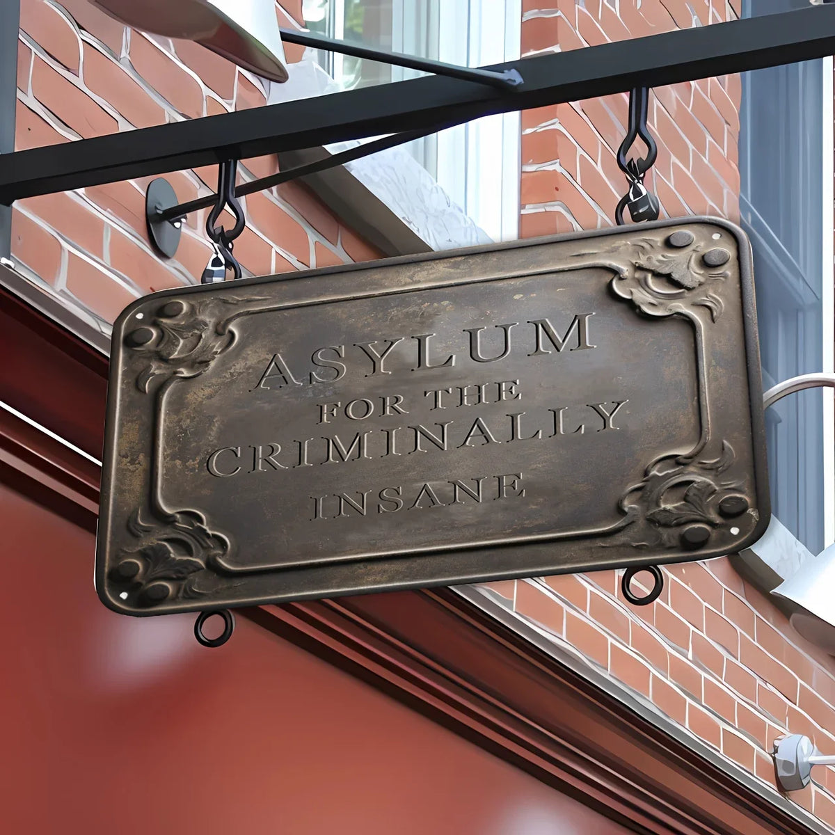 A vintage metal tin sign for wall décor with the inscription Asylum for the Criminally Insane.