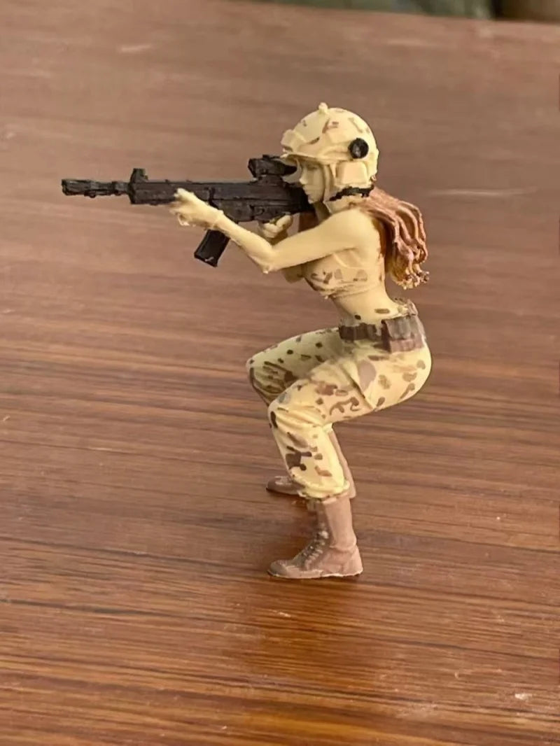 A tactical female rifleman desktop figurine in camouflage attire aiming a rifle.