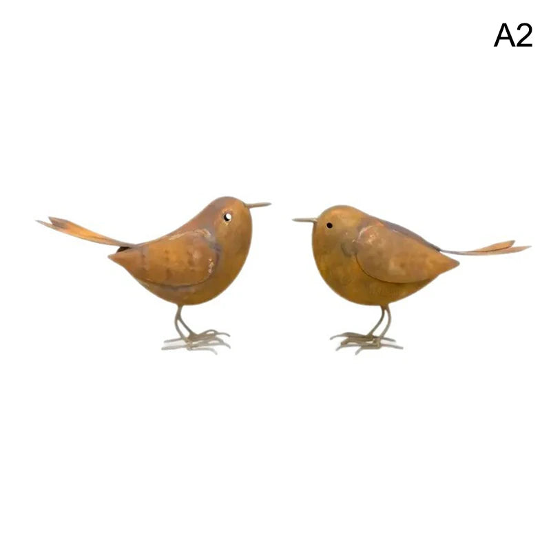 A pair of rustic metal bird sculptures with brown and tan coloring.