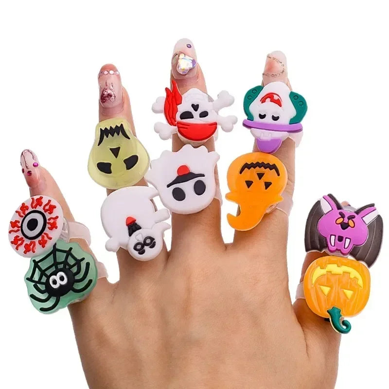A hand displays various Halloween glow rings featuring spooky characters and colors like orange, purple, green, and white.
