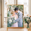 A framed photo of a couple embracing, featuring soft lighting and greenery.