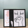A set of three black picture frames with acrylic fronts displaying hand and abstract shapes.