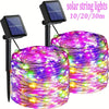 A bundle of colorful LED string lights wrapped around a cylindrical object, powered by solar panels.