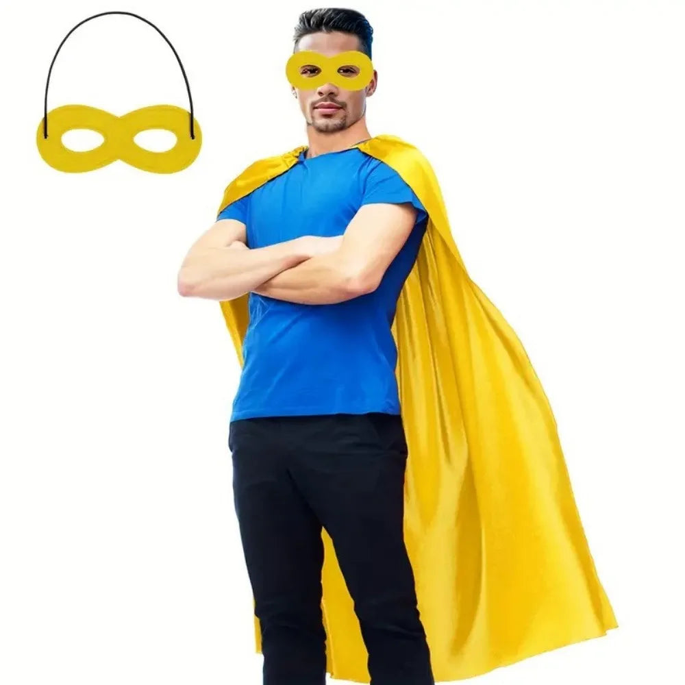 A man wearing a blue shirt and black pants with a yellow superhero cape and yellow eye mask.