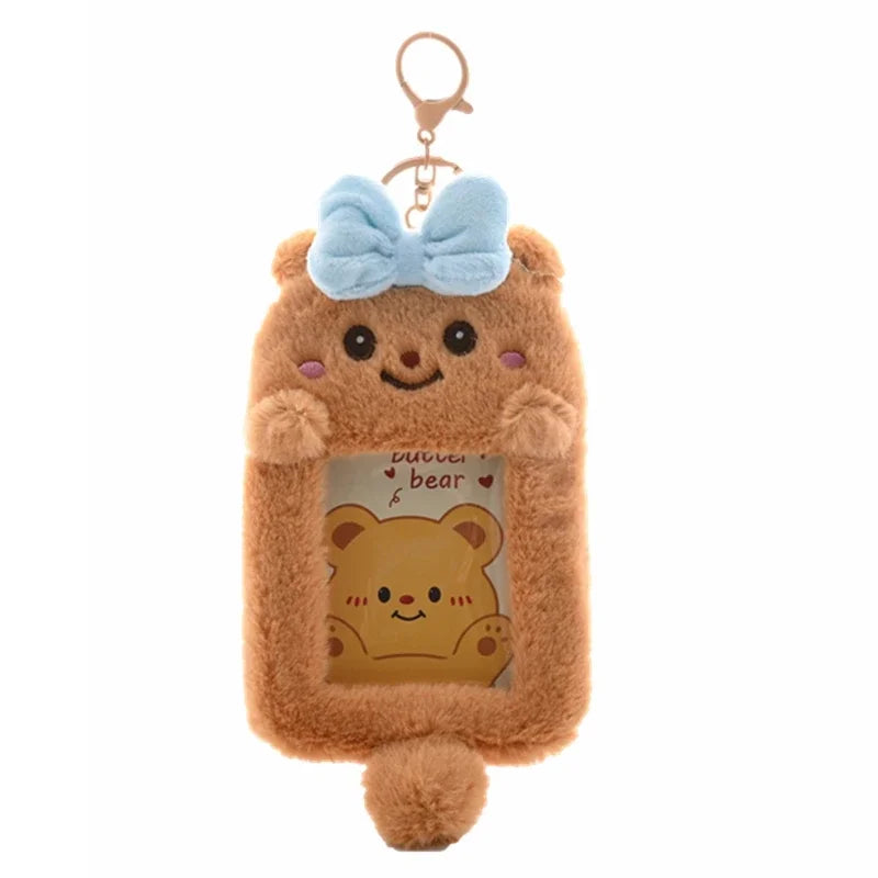 A fluffy brown bear keychain with a light blue bow and a clear window displaying another bear.