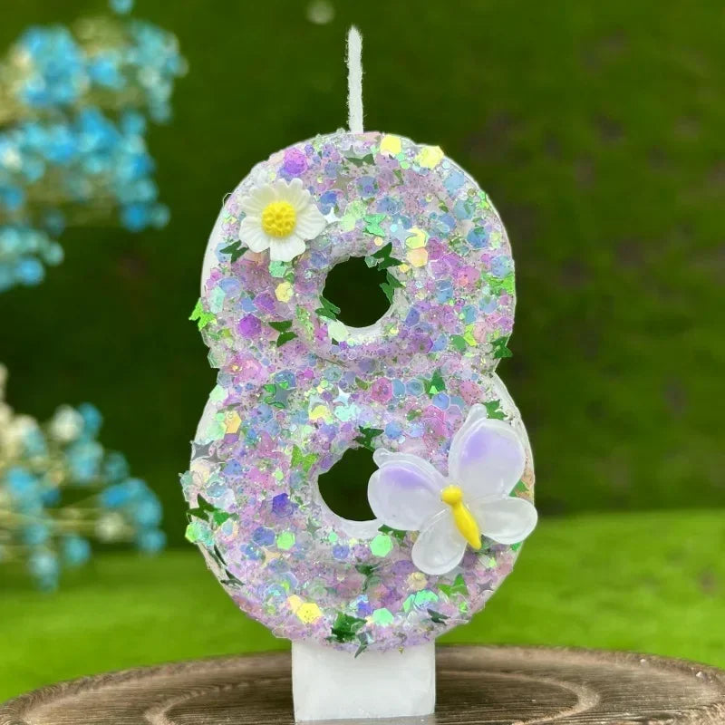A purple number eight cake candle decorated with small flowers and a white butterfly on a white stand.