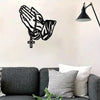 Black silhouette of an open hand with a prayer chain and cross, mounted as wall art.
