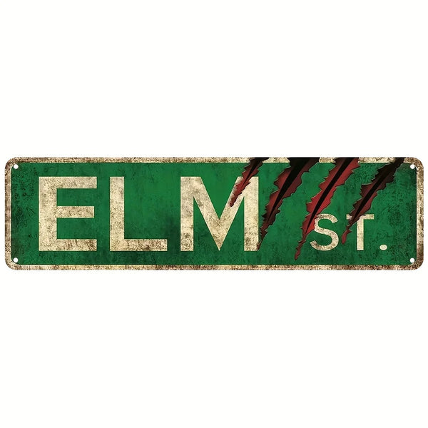 A rectangular metal street sign with green background and distressed texture displaying ELM St.