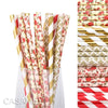 A glass filled with a pack of colorful striped and polka dot paper drinking straws in red, gold, and pink.