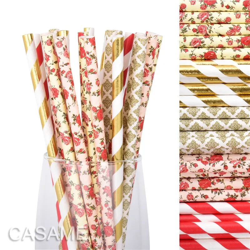 A glass filled with a pack of colorful striped and polka dot paper drinking straws in red, gold, and pink.