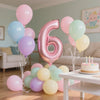 Collection de ballons en feuille rose et bleu clair formant le chiffre six pour une fête d'anniversaire.