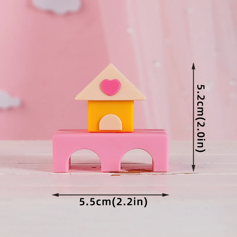 Pink and yellow baby blocks cake toppers featuring a house shape with a heart detail