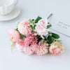 A bouquet of pink and peach artificial silk peony flowers arranged on a white surface.