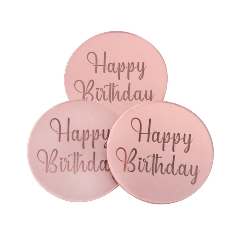 Two round pink acrylic birthday cake toppers with the text Happy Birthday